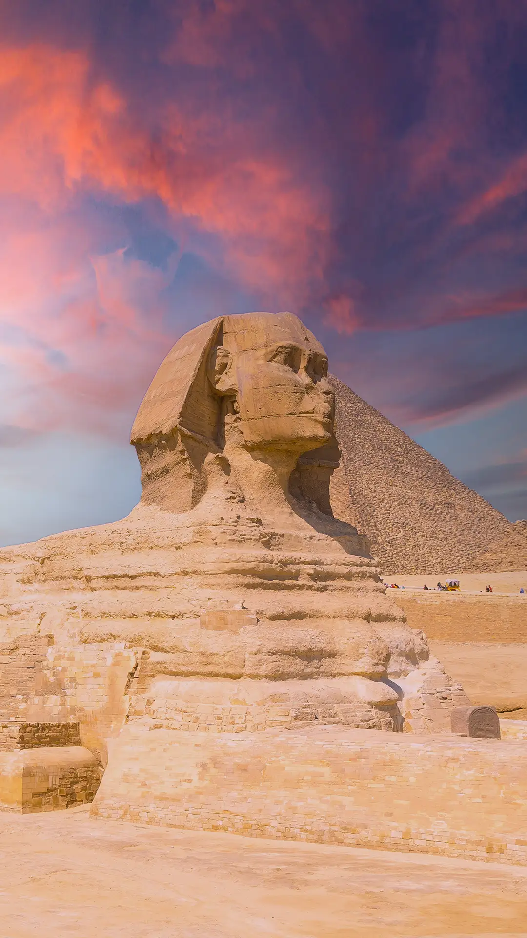 The Great Sphinx of Giza and in the background the Pyramids of Giza at sunset, the oldest funerary monument in the world.