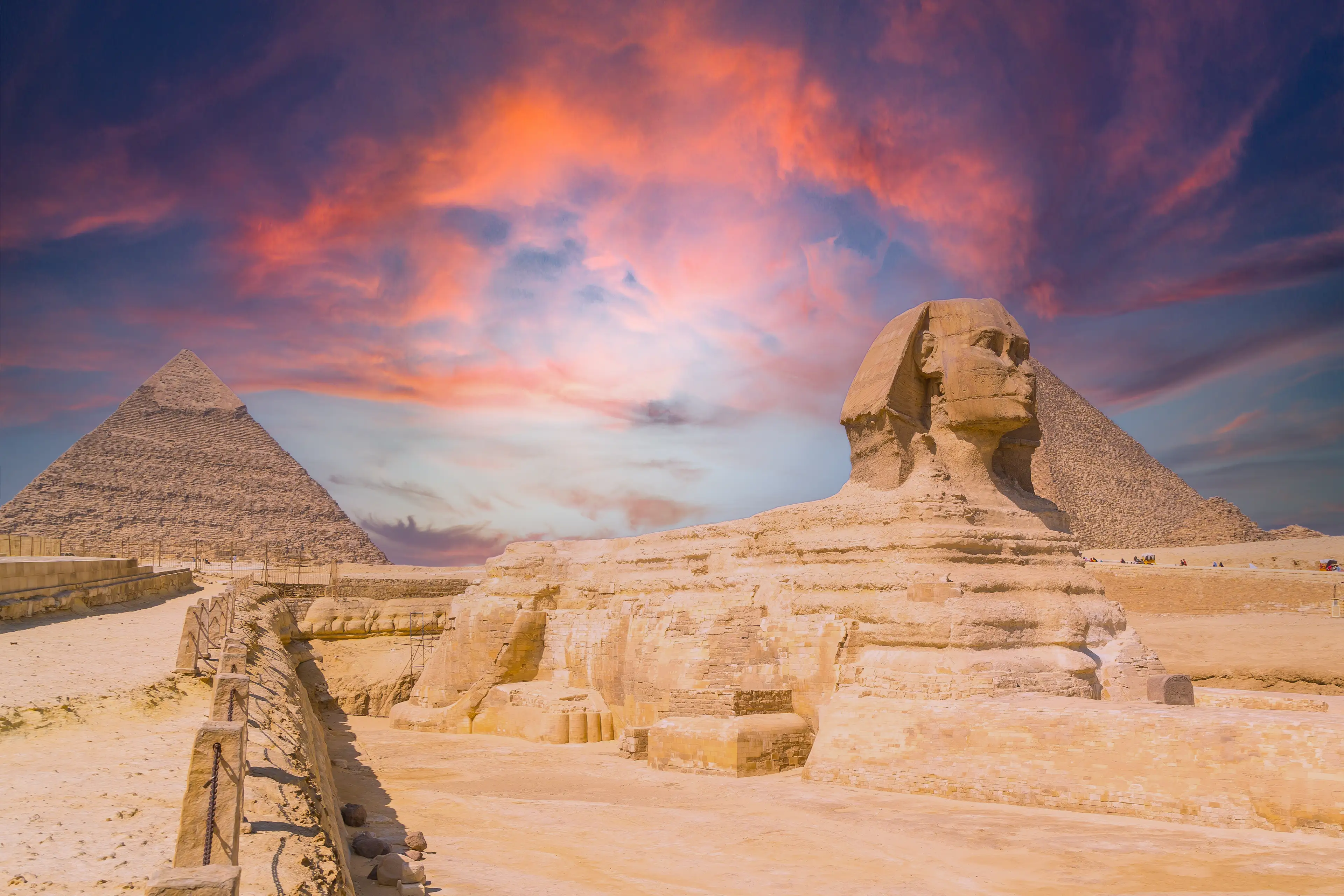 The Great Sphinx of Giza and in the background the Pyramids of Giza at sunset, the oldest funerary monument in the world.