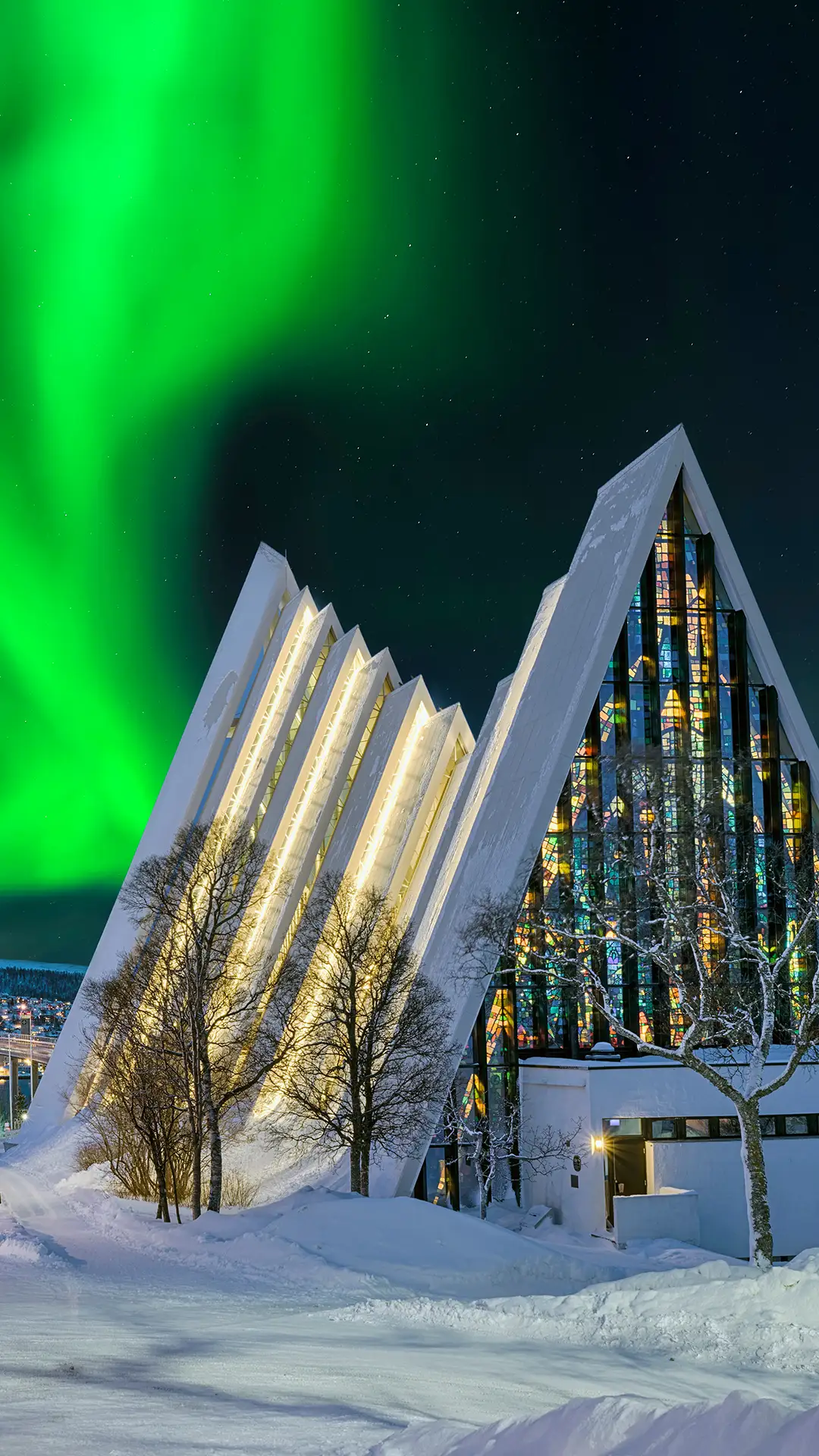 Arctic Cathedral in Tromso at night with aurora borealis in the sky.