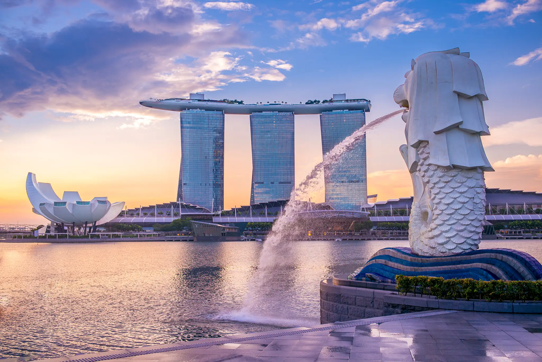Silhouette of Merlion Statue in Singapore with Marina Bay Sands in the background.