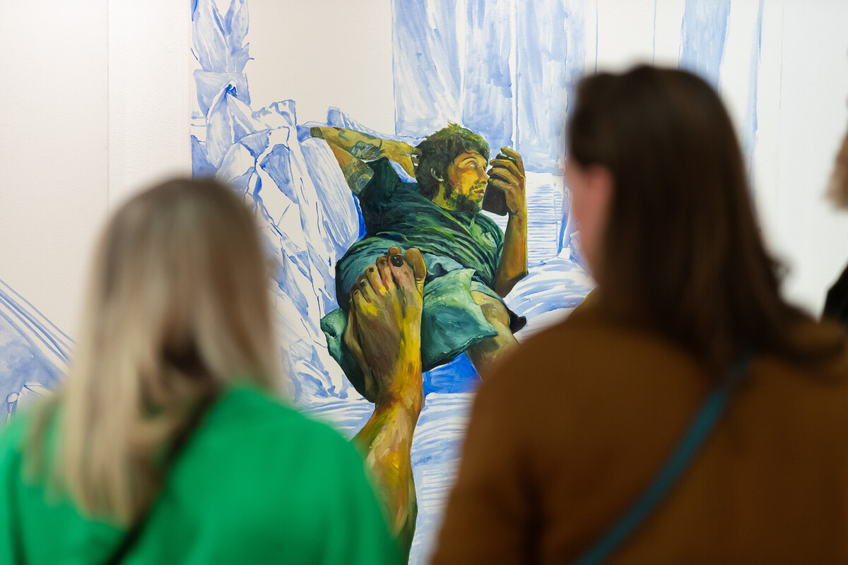 People looking at a painting on a wall