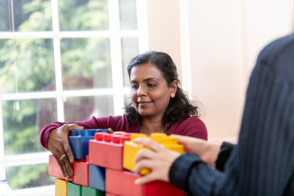 woman with multi-coloured play building blocks