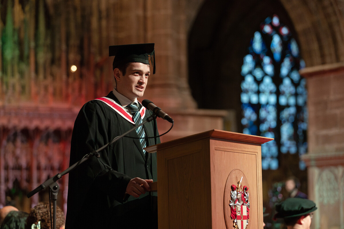 A student at a lectern during graduation