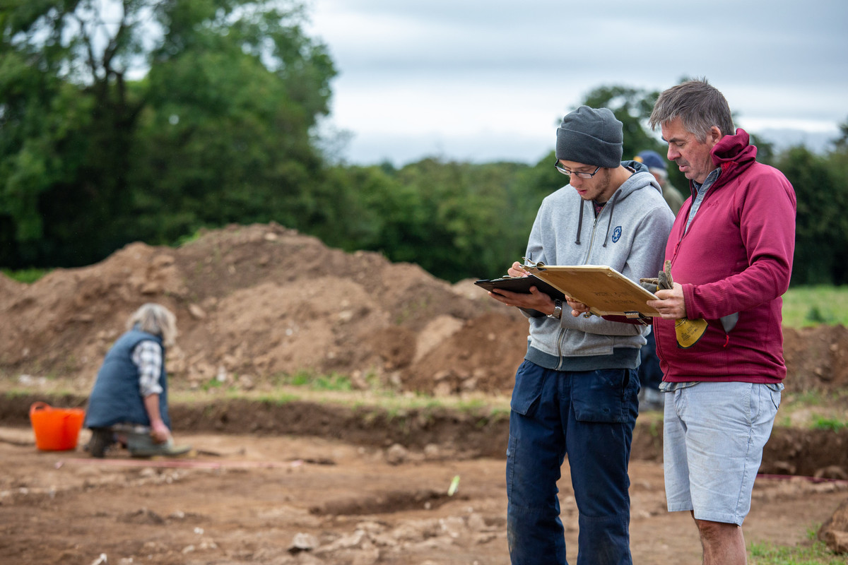 Two people with review the archaeological dig of a Roman villa site.