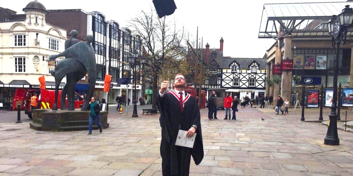 A student is celebrating his graduation in the city centre