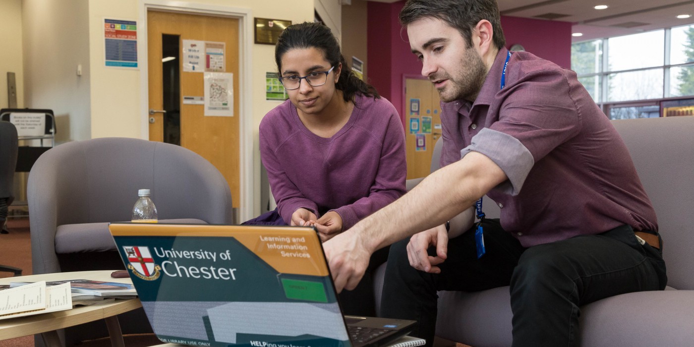 A Chester University member of staff and a student looking at a laptop
