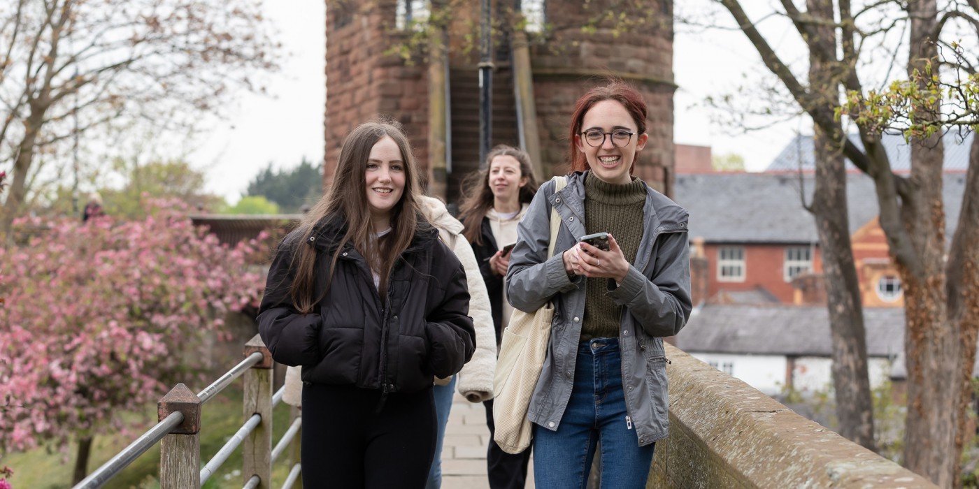 A group of female students walking on the historic Chester walls.