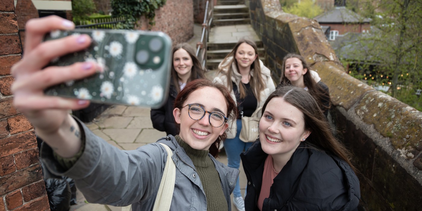 Students having fun taking a selfie on Chester's city walls