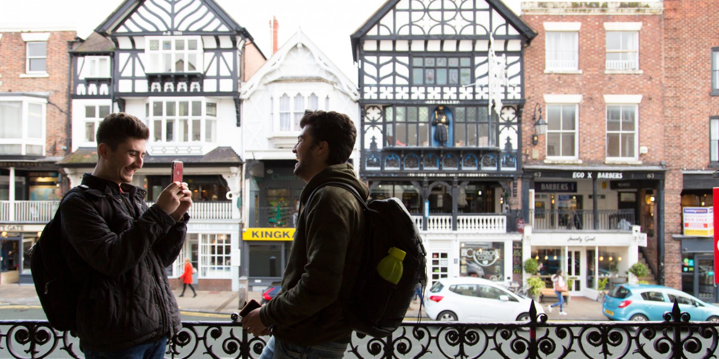 Two students having fun taking photos in Chester city centre