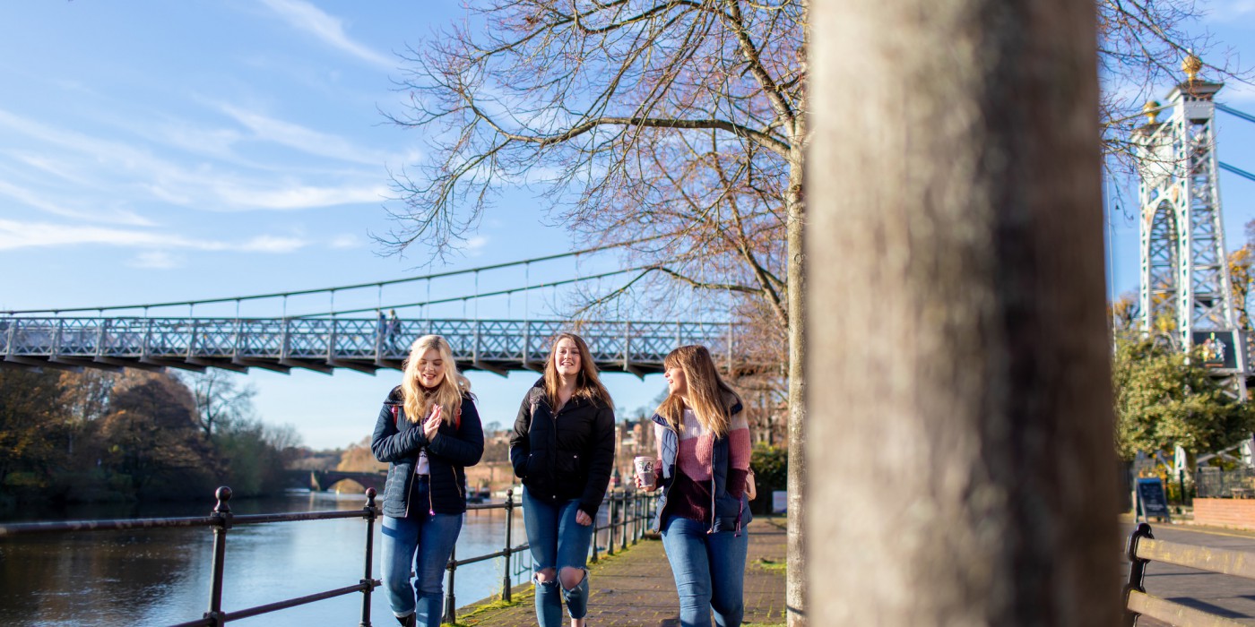 Three students walking by the River Dee in Chester City Centre