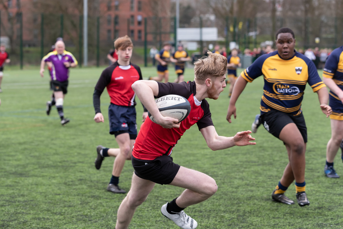 Rugby sport teams playing on an outdoor pitch.