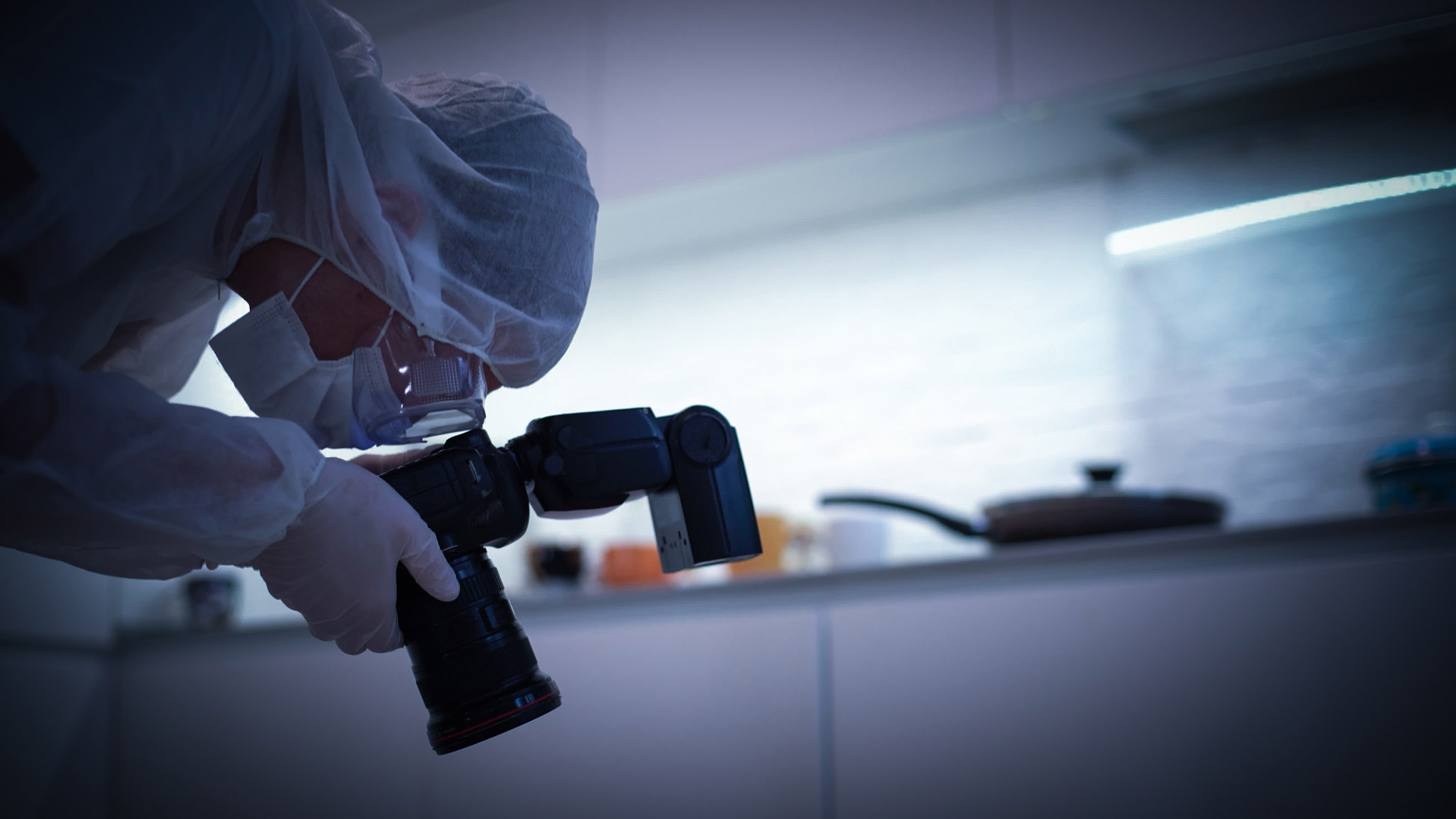 A person forensically investigates a surface with a camera